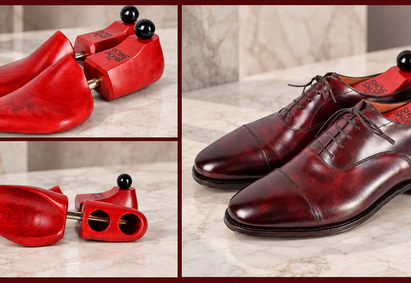 A pair of polished burgundy leather dress shoes with matching red wooden shoe trees, featured in a guide to shoe trees.