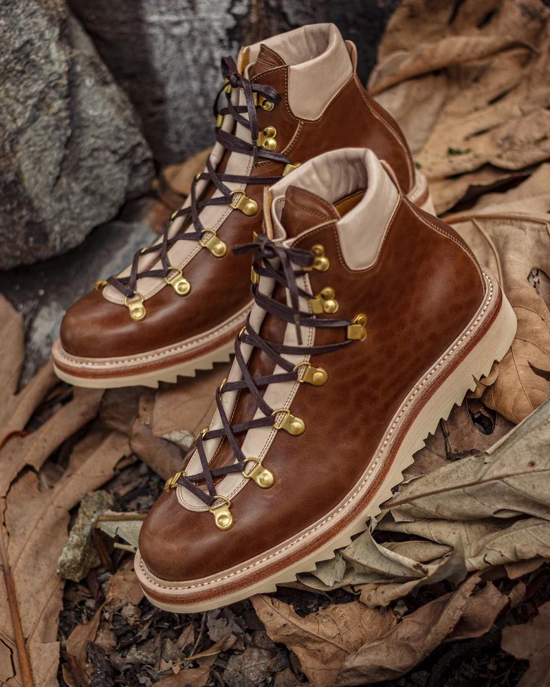 A pair of brown leather hiking boots with gold eyelets and dark laces.