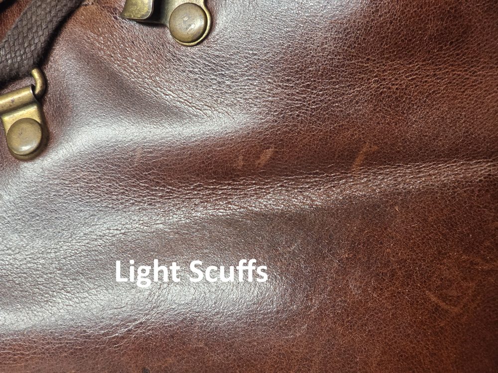 Close-up of brown leather showing light scuffs and a textured surface.