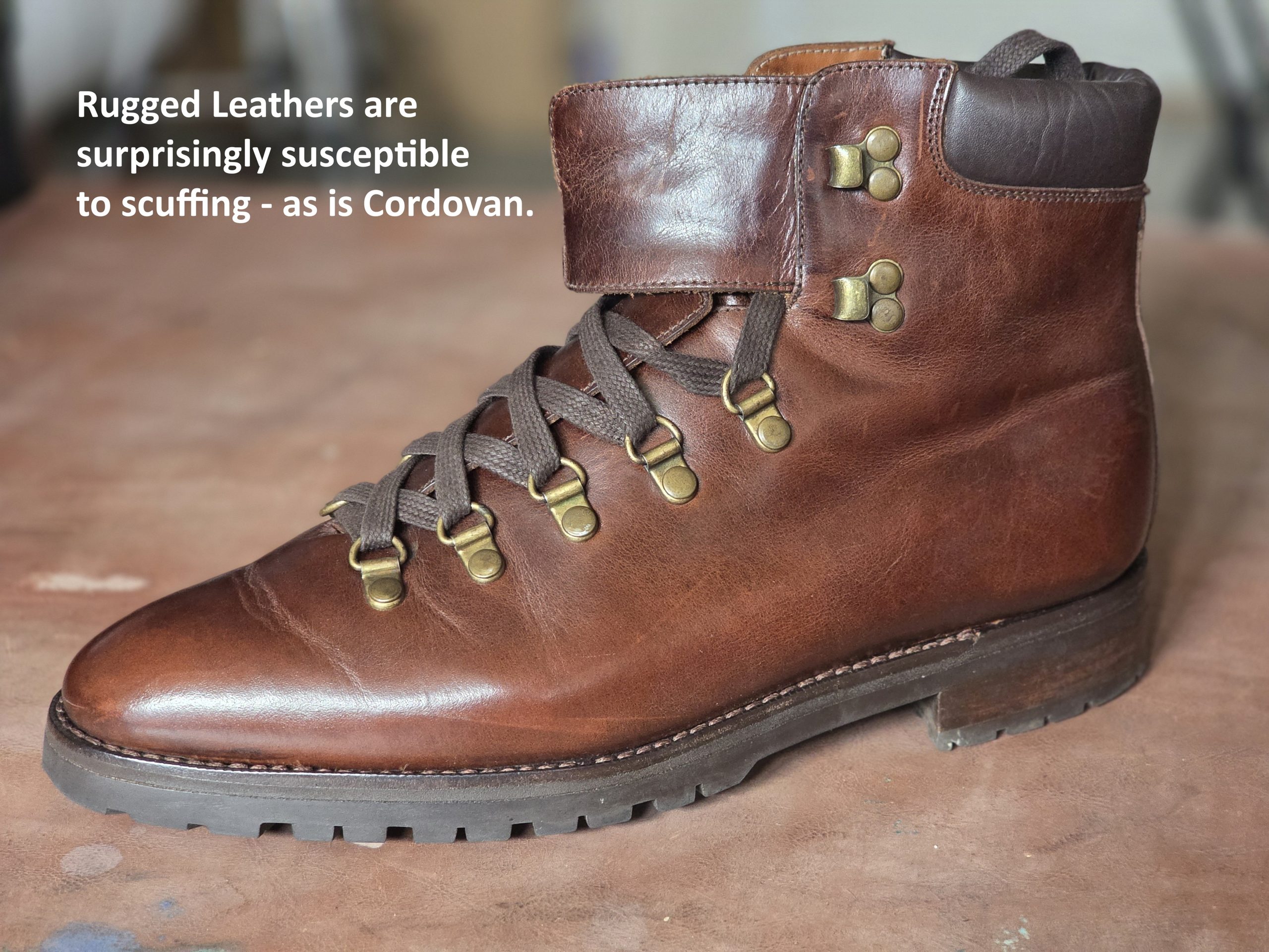 A rugged brown leather boot with brass eyelets and brown laces.