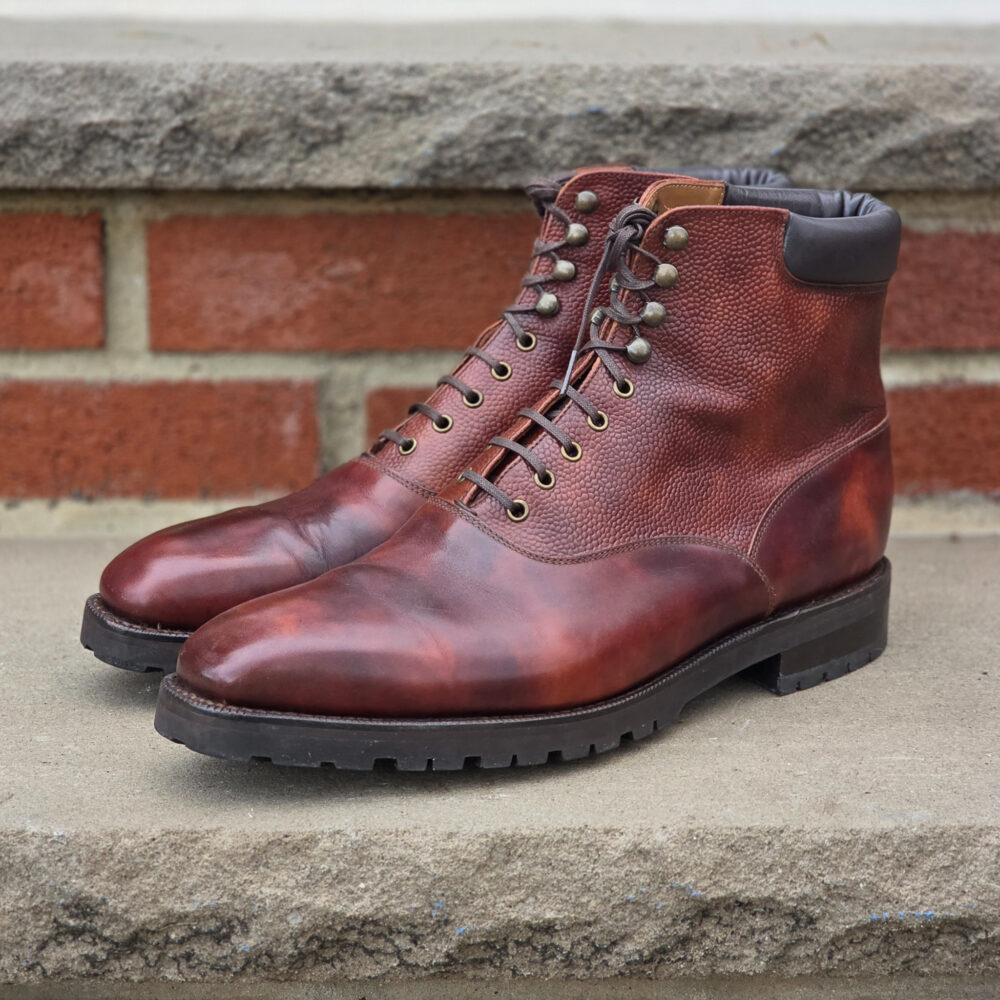 Brown leather ankle boots with a textured finish and metal eyelets.