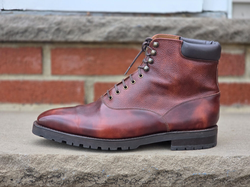 A brown leather boot with a textured finish and black rubber sole.