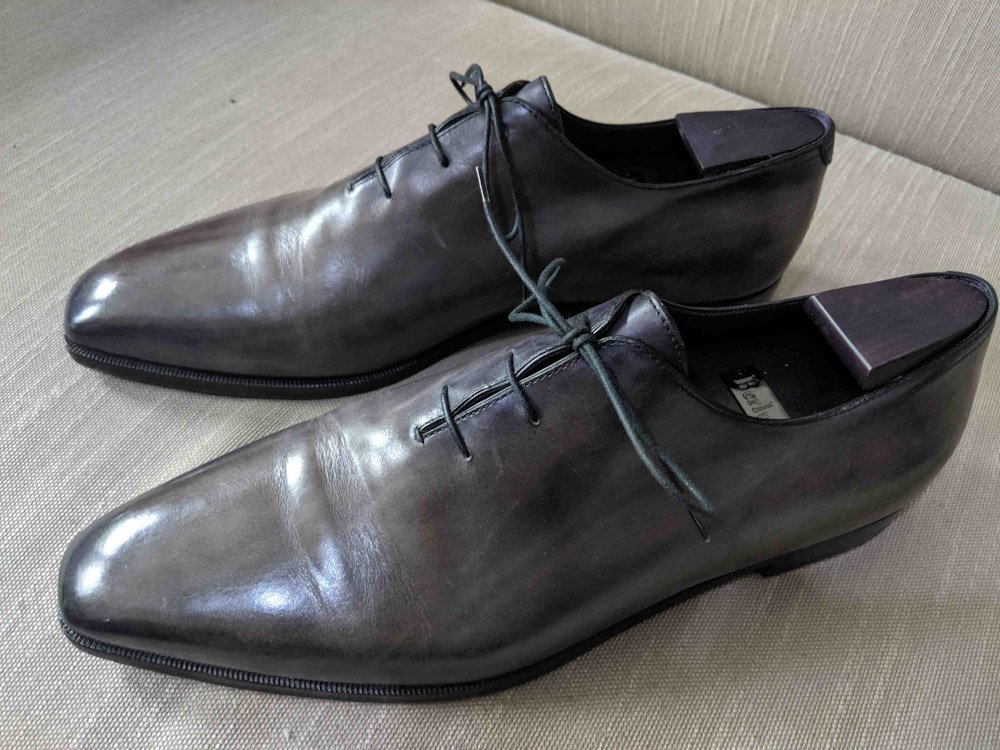 A pair of polished dark brown leather dress shoes with laces.