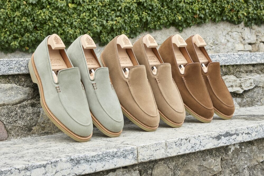 Three pairs of suede slip-on shoes in green, tan, and brown, highlighting craftsmanship related to Shoe Industry Lies.