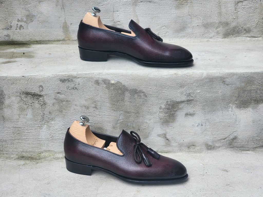 A pair of burgundy leather shoes with a textured finish and decorative laces, highlighting Shoe Industry Secrets.