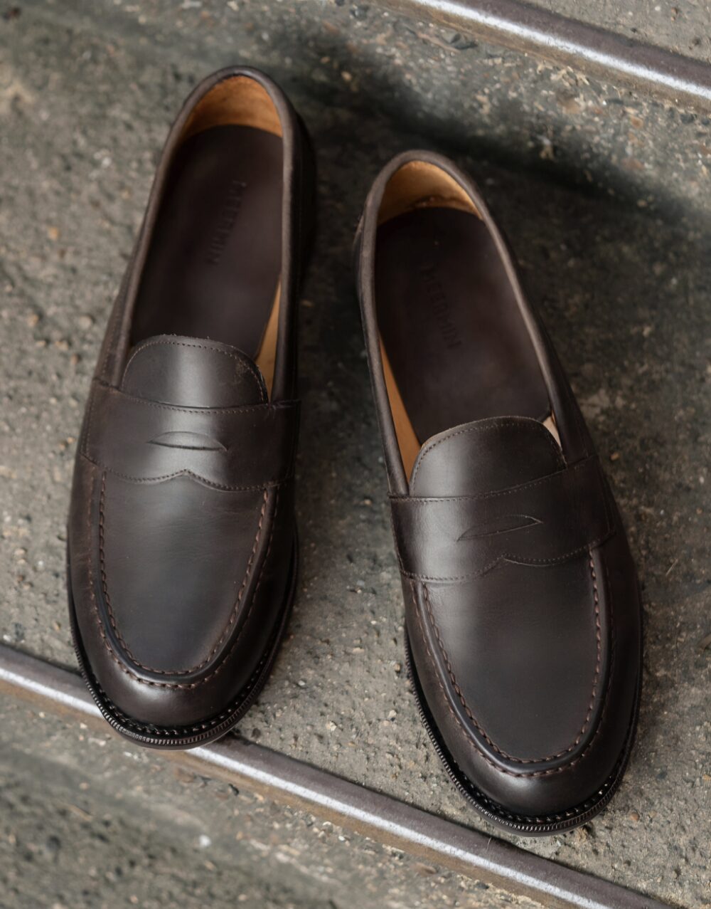 A pair of brown leather loafers with a smooth finish and stitched detailing.