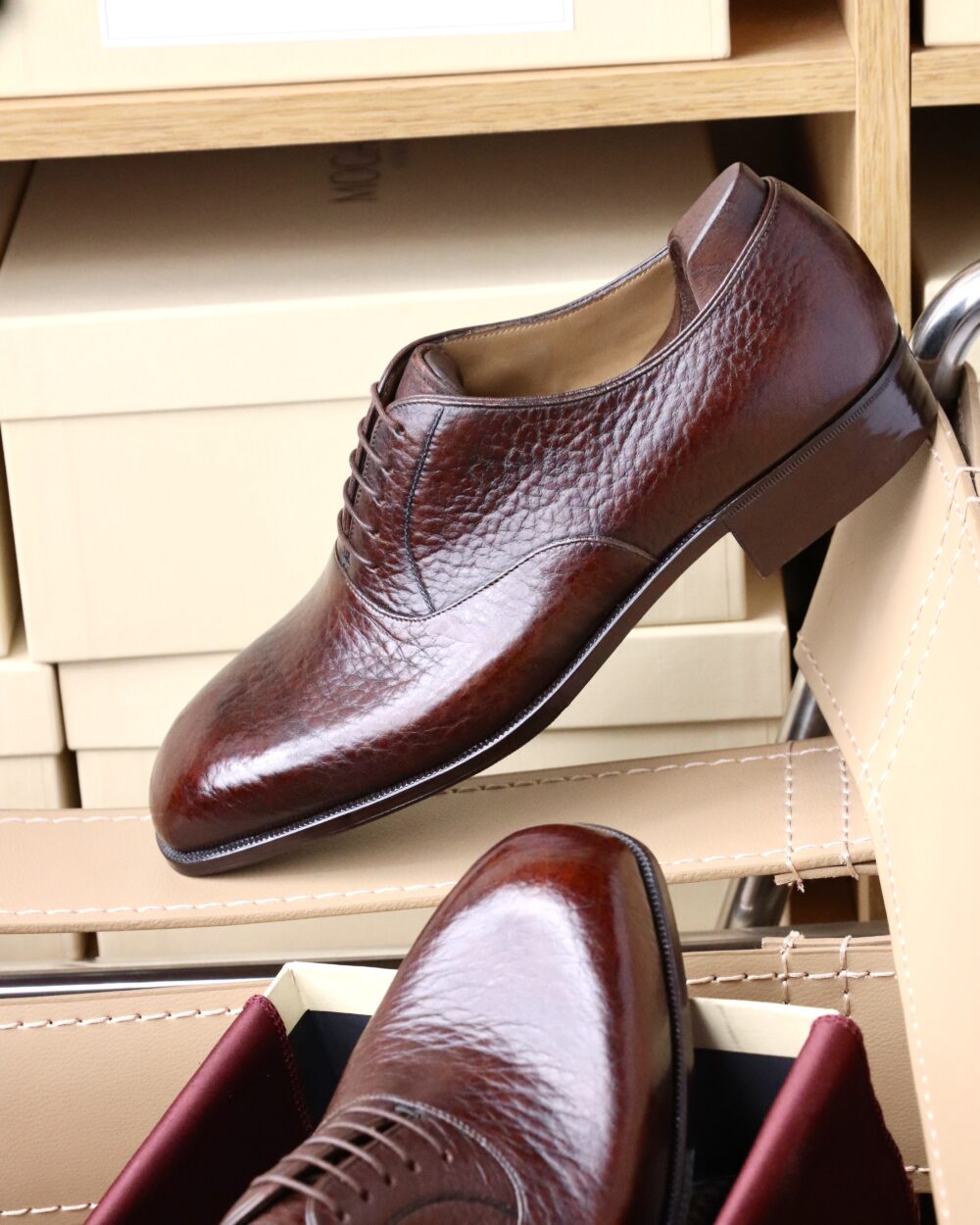 A polished brown leather dress shoe with a rounded toe and laces.