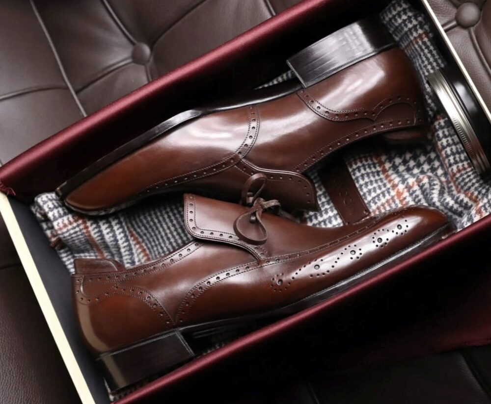 A pair of polished brown leather dress shoes with brogue detailing, made by Louis Lampertsdörfer