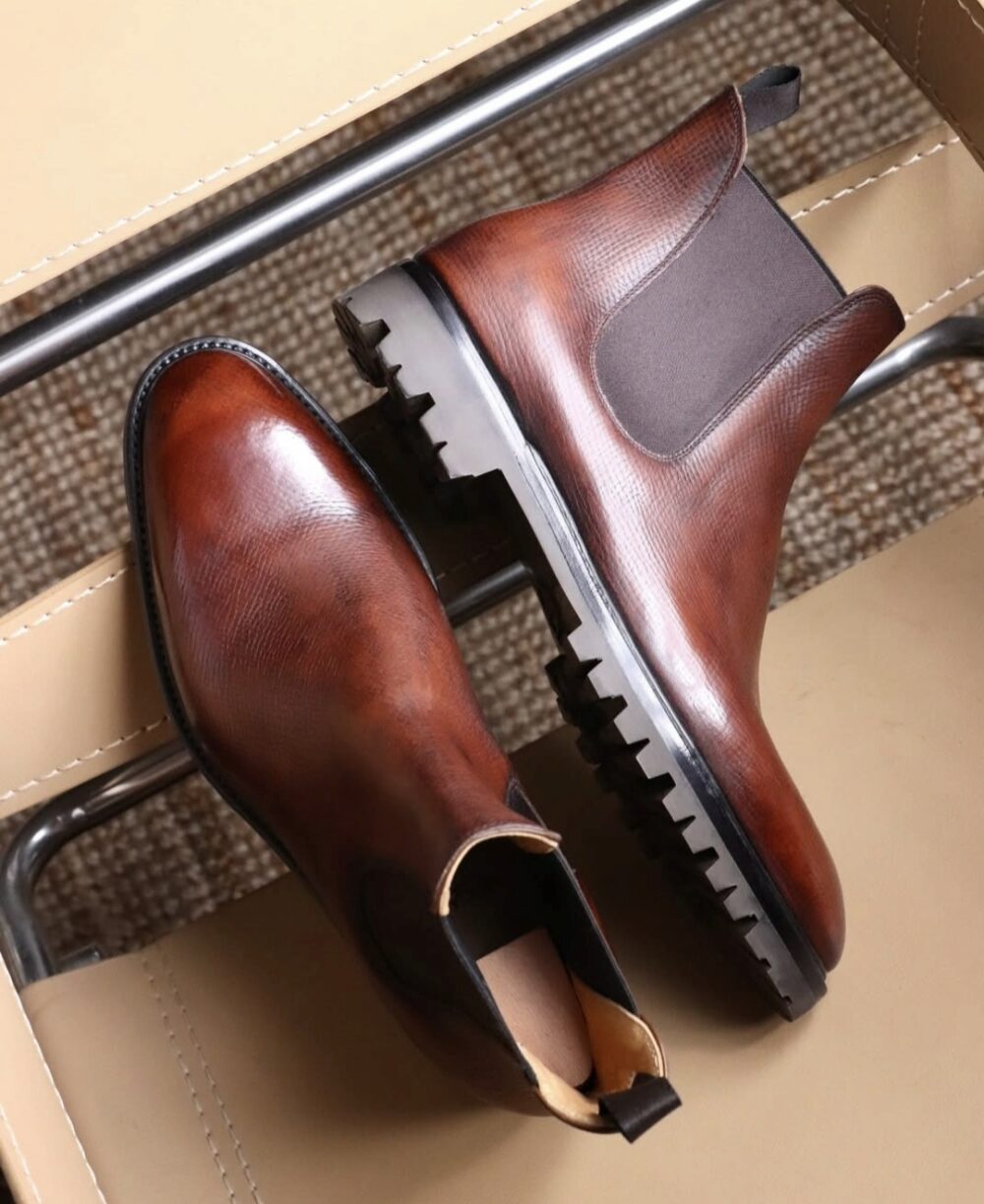 Brown leather Chelsea boots with a textured finish and rubber soles.
