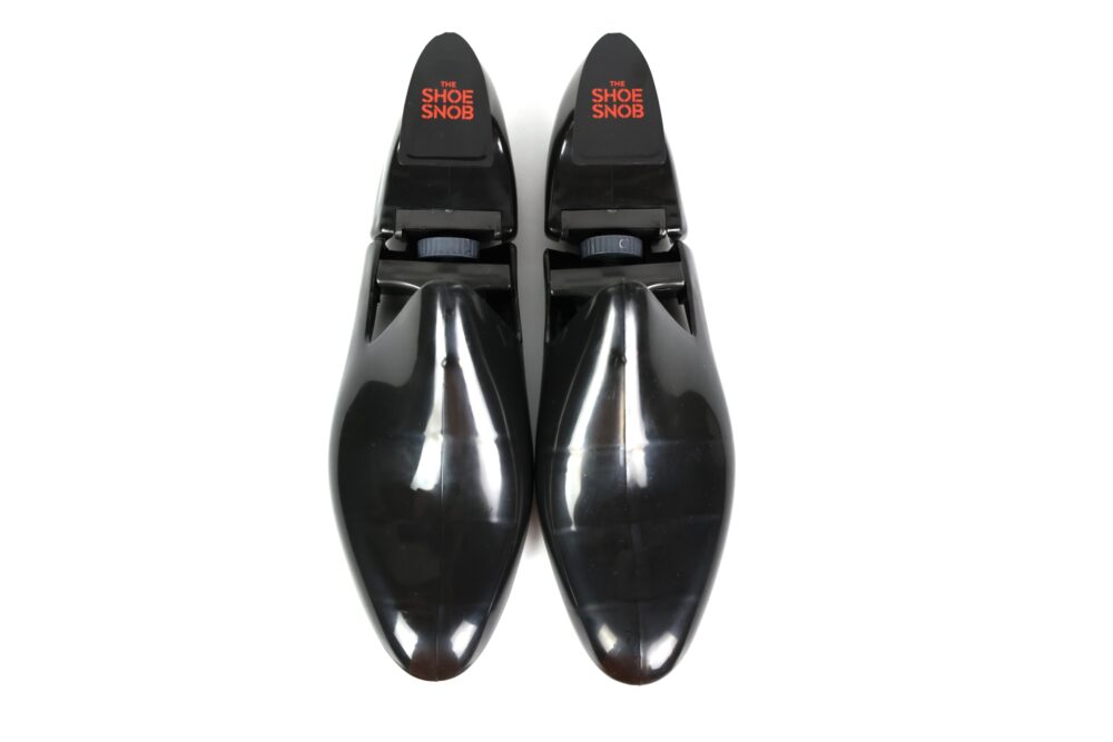 A pair of black shoe stretchers with "THE SHOE SNOB" printed in red on the top.