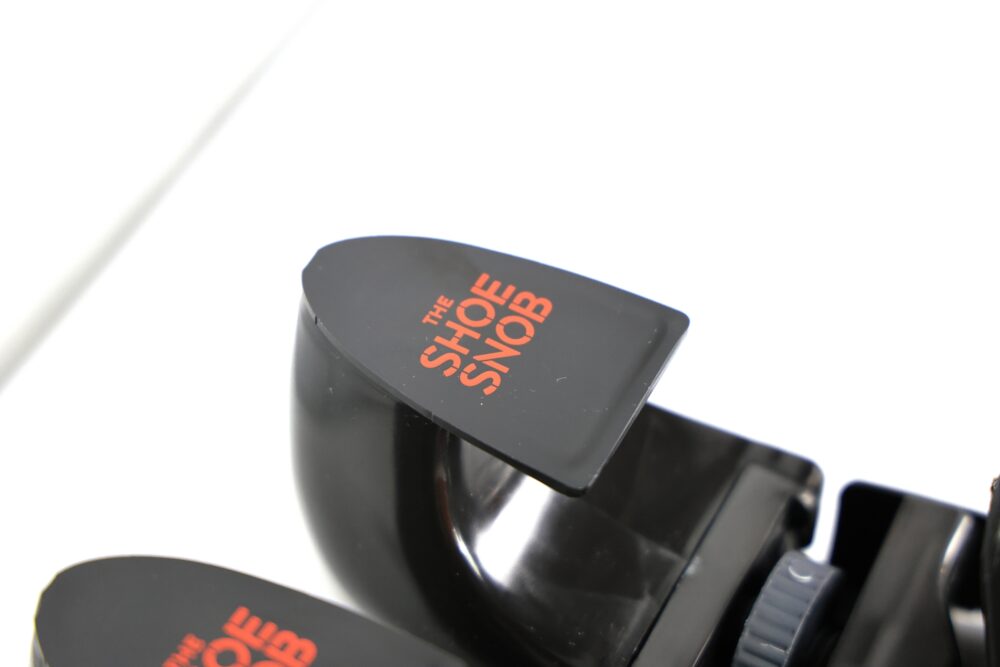 A black shoehorn with "THE SHOE SNOB" printed in red.