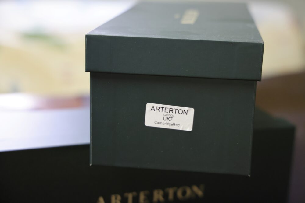 A green shoebox labeled "Arterton London UK7 CambridgeRed."