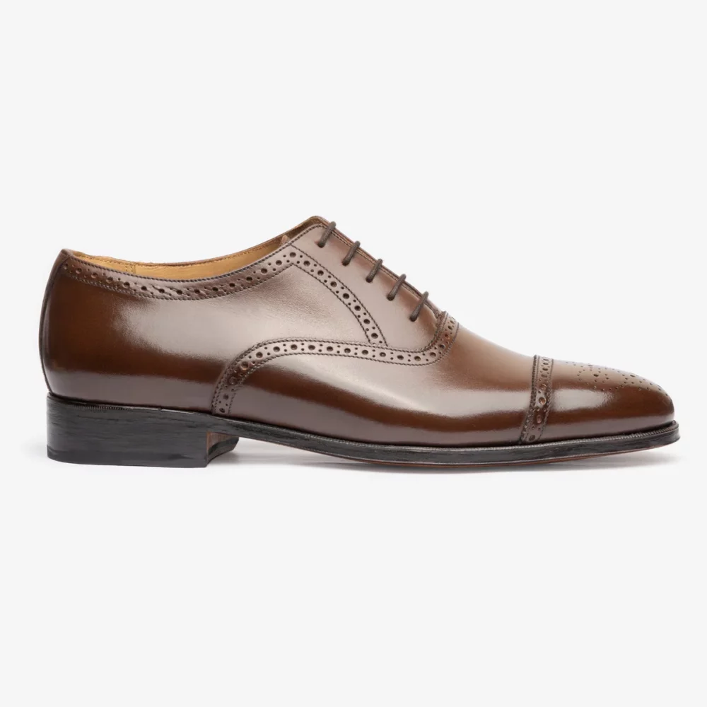 Brown leather dress shoe with a cap toe and perforated detailing.