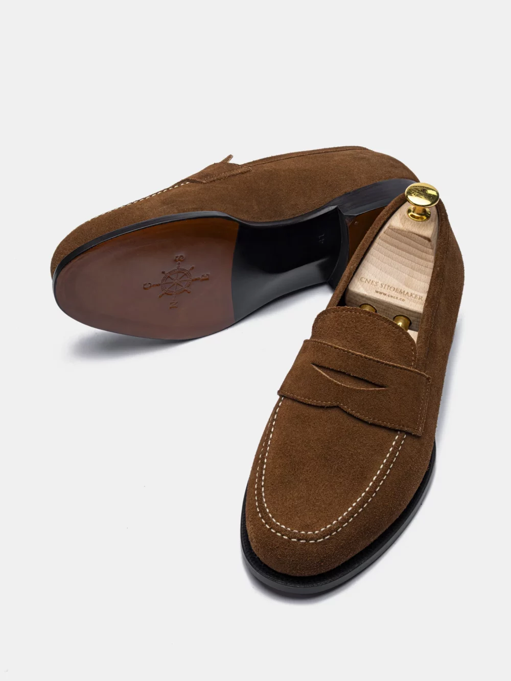 Brown suede loafers with a stitched design and a black sole.