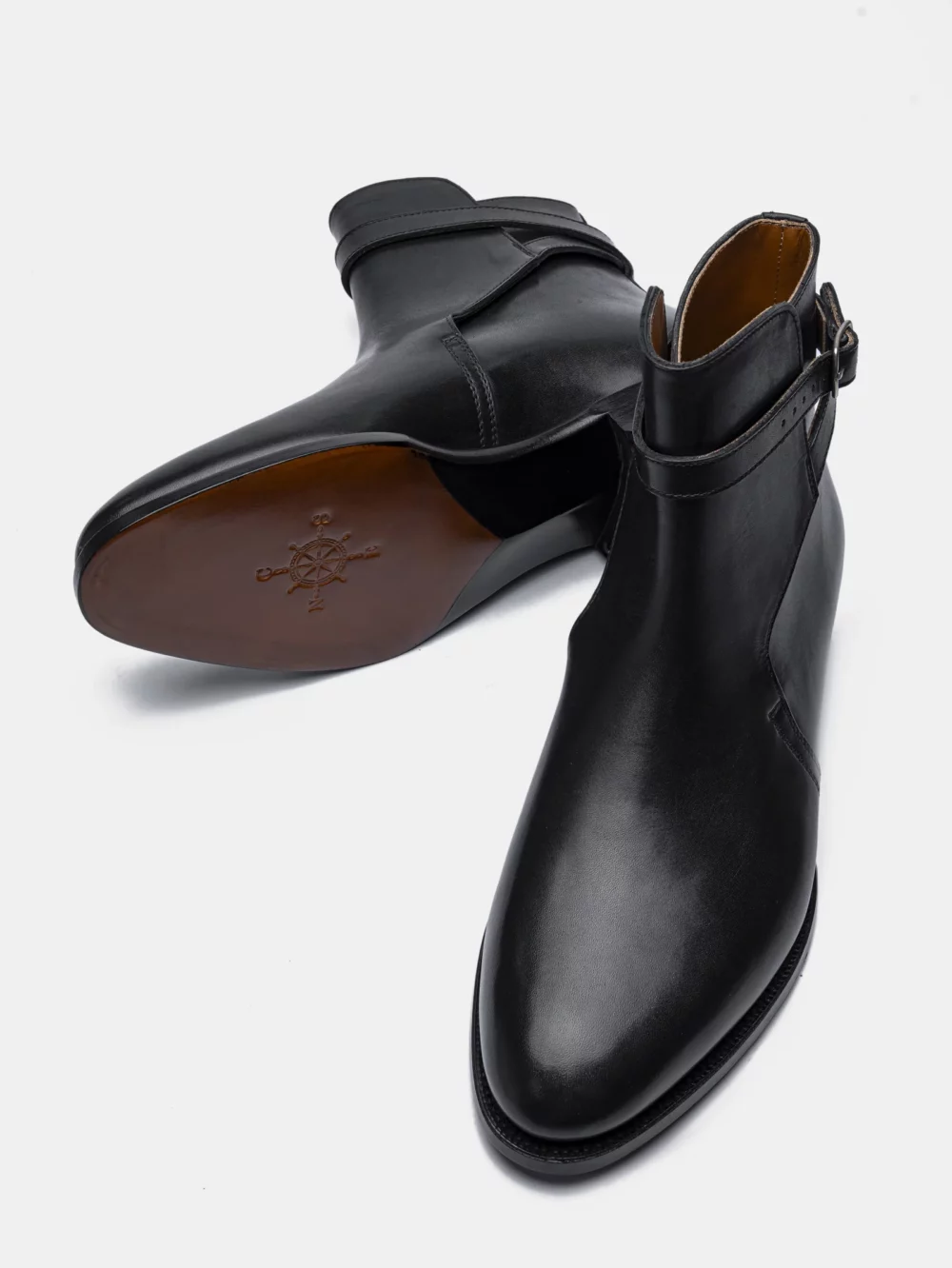 A pair of black leather ankle boots with a sleek design and a side buckle.