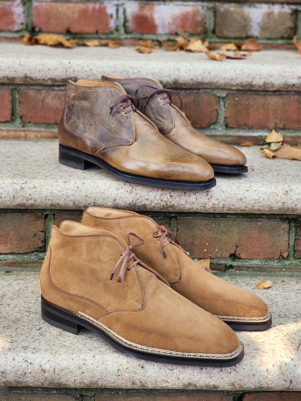Two pairs of stylish boots: one in brown leather with a smooth finish and the other in tan suede with a textured surface.