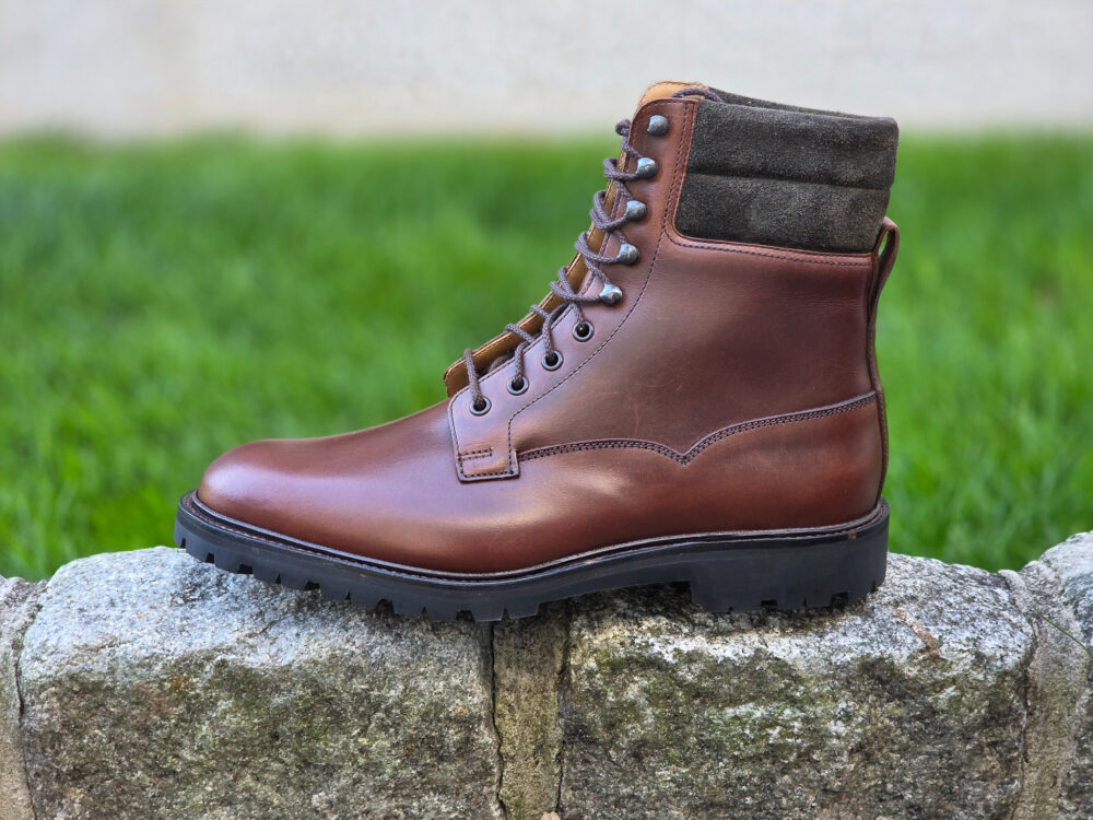 A brown leather boot with a suede collar and a rugged sole.