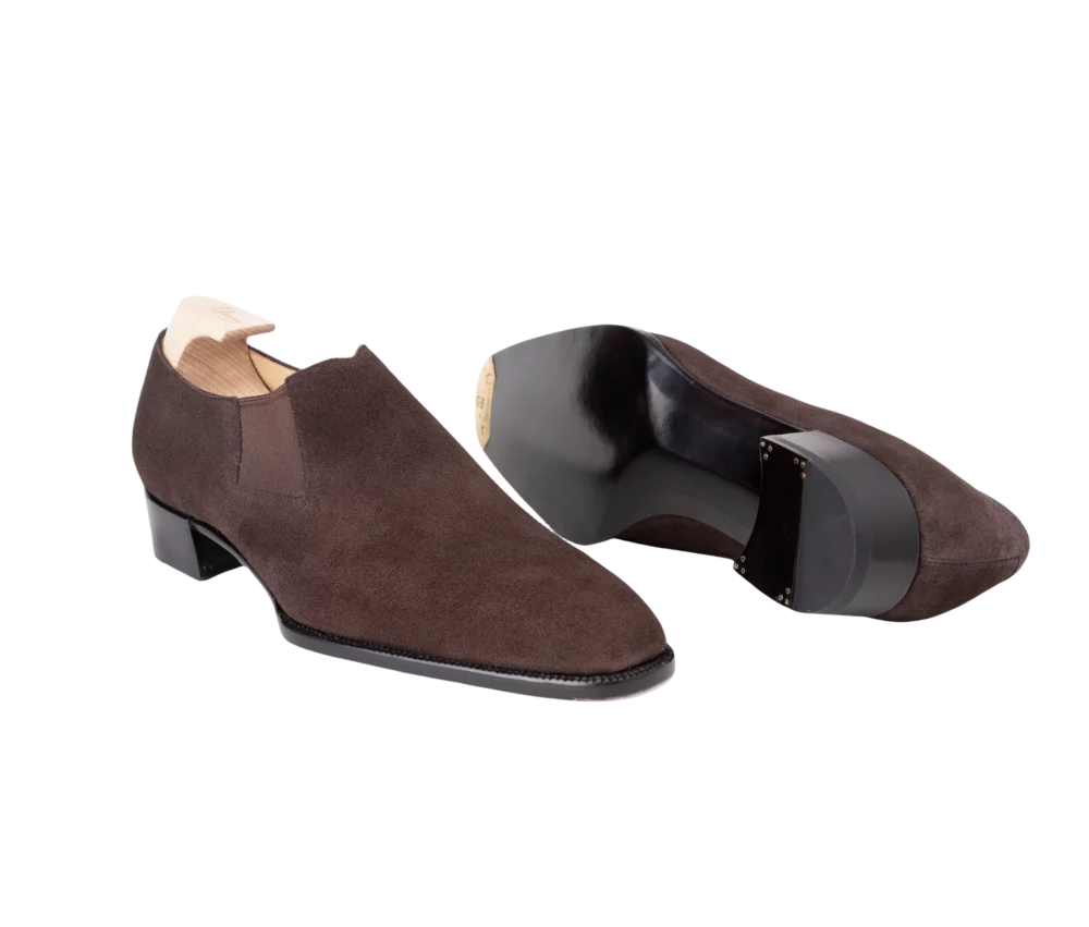 A pair of brown suede dress shoes with a low heel and a sleek design.