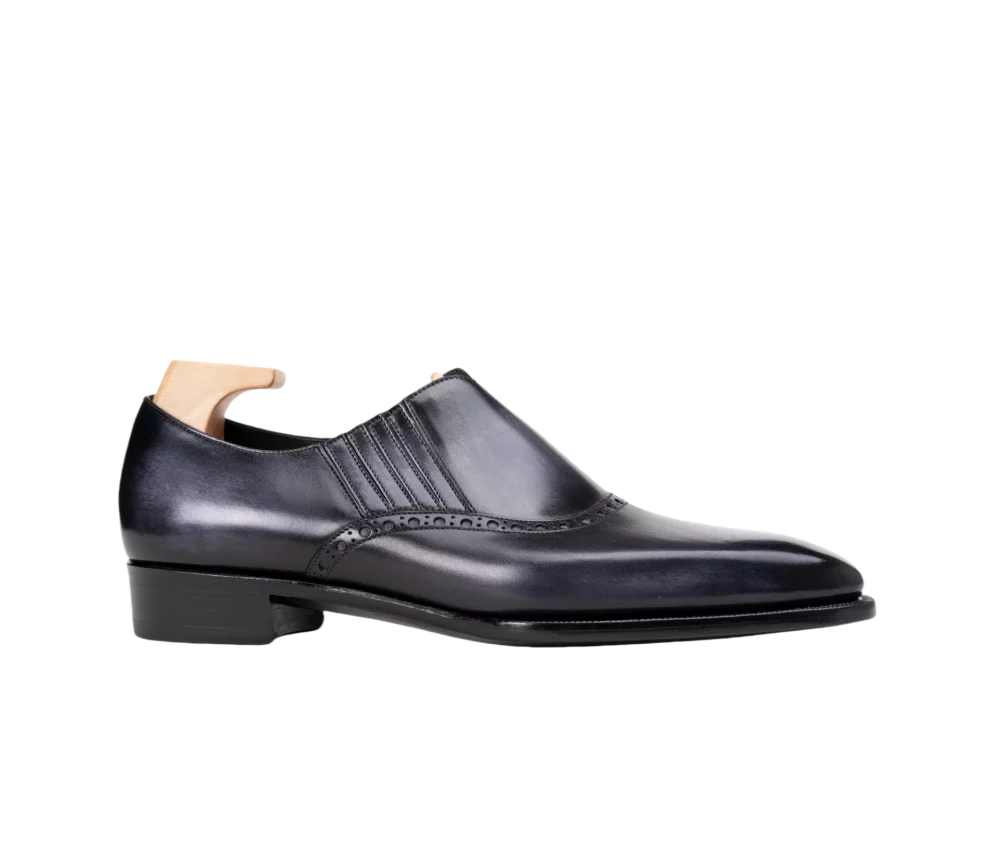 A sleek black leather dress shoe with a pointed toe and decorative stitching.