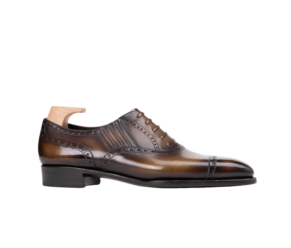 Brown leather dress shoe with decorative perforations and a sleek design.