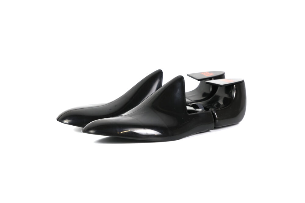 A pair of shiny black high-heeled shoes with pointed toes.