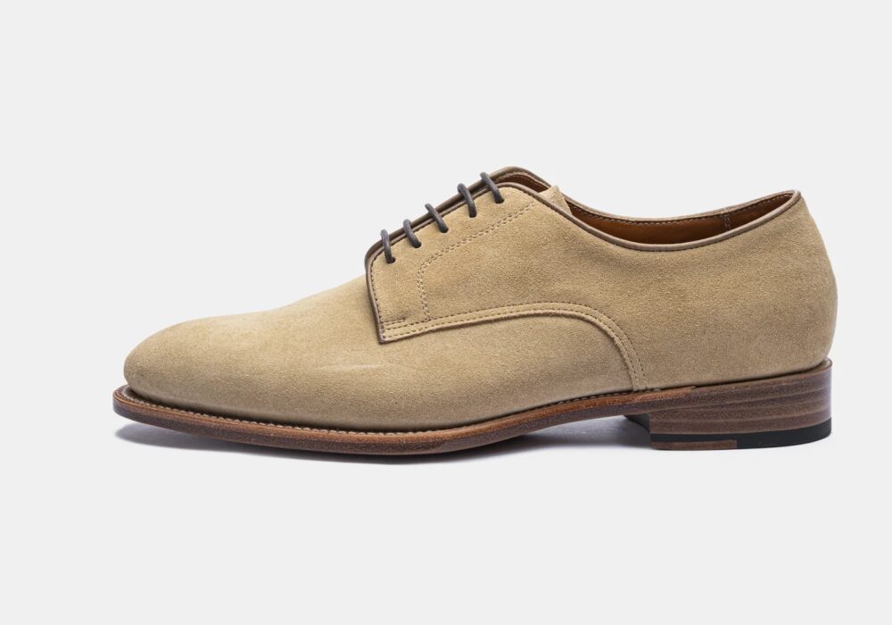 Beige suede dress shoe with a rounded toe and brown leather sole.
