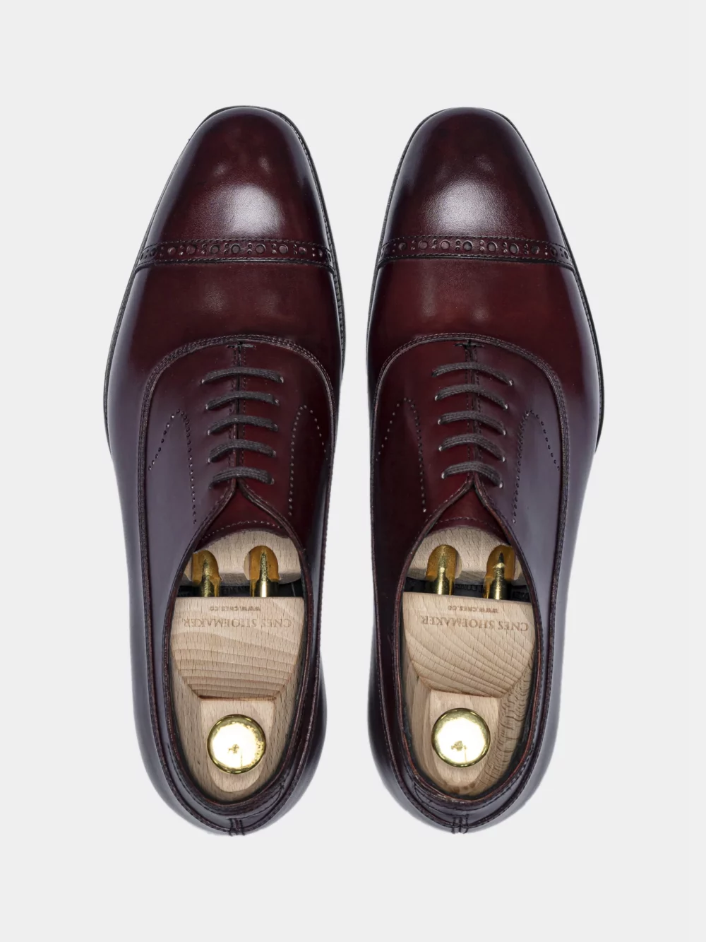 A pair of polished burgundy leather dress shoes with decorative broguing in the CNES Spring Sale 2026