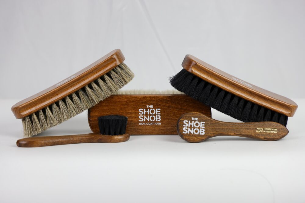 Three shoe brushes with wooden handles, featuring goat hair and horsehair bristles.