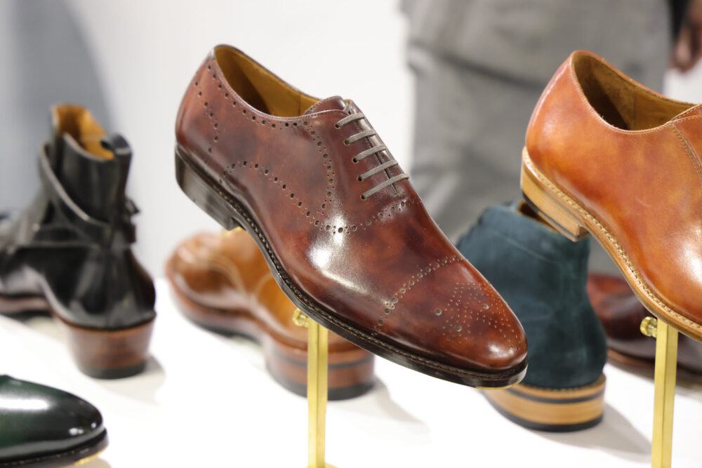 A polished brown leather dress shoe with decorative perforations and laces.