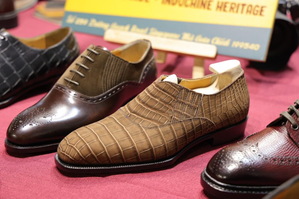 A collection of elegant shoes featuring brown crocodile leather, dark brown polished leather, and a textured brown suede style.