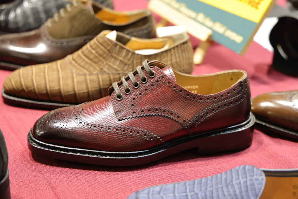 A polished burgundy leather dress shoe with decorative perforations and laces.