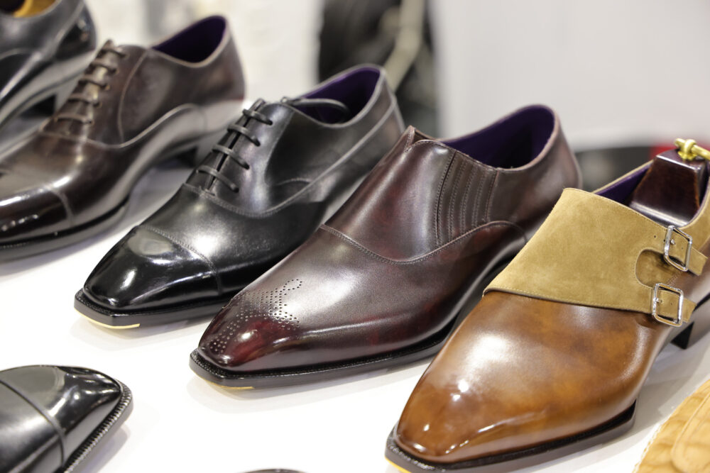 A selection of stylish leather dress shoes in black, dark brown, and tan, featuring various designs and textures.