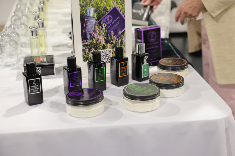 A display of various black bottles of grooming products and jars of cream, labeled with colors like green, orange, and purple.