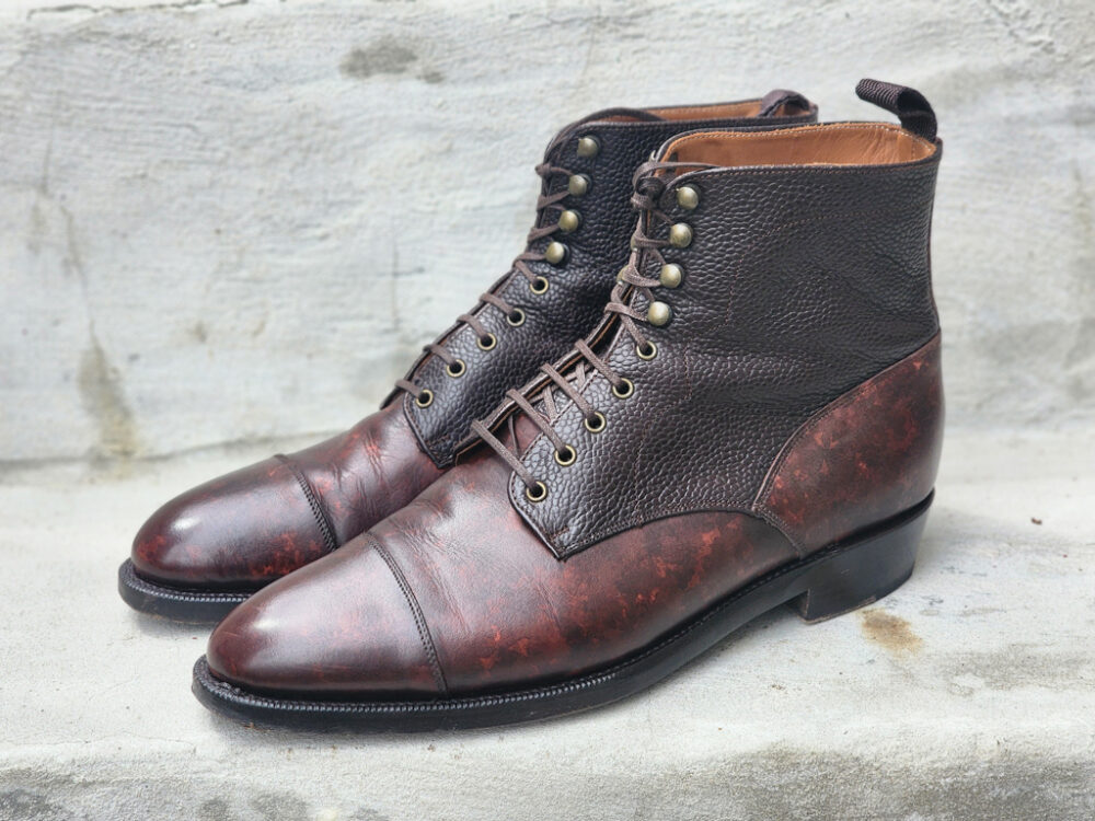 A pair of brown leather ankle boots with a textured finish and a smooth toe cap.