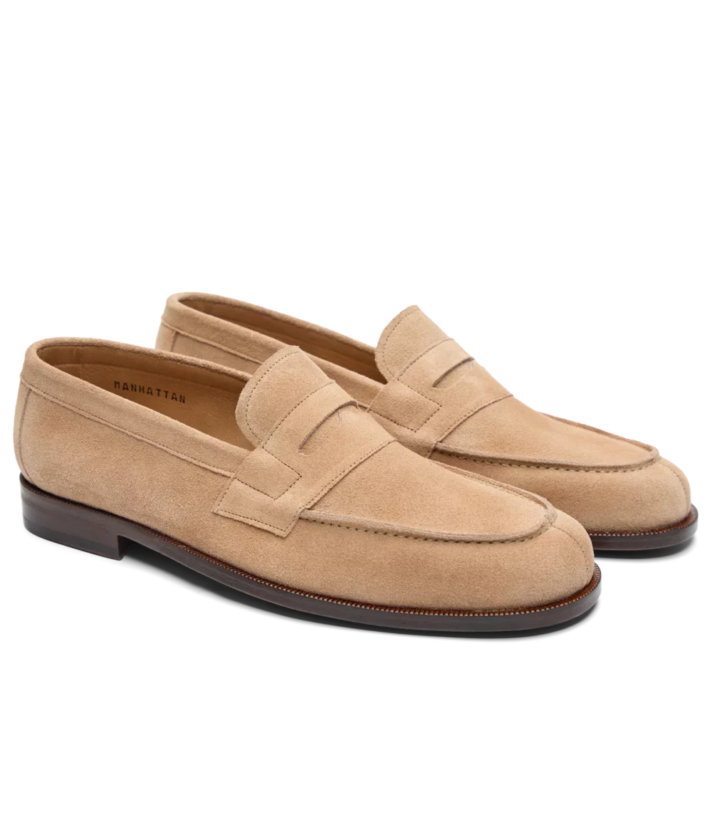 Tan suede loafers with a stitched design and a low heel.