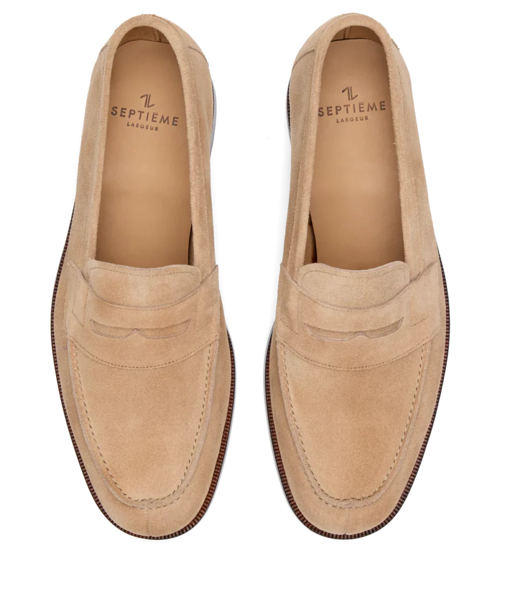Tan suede loafers with a slip-on design and a stitched detail on the upper.