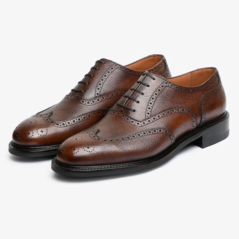 Brown leather dress shoes with a brogue design and laces.