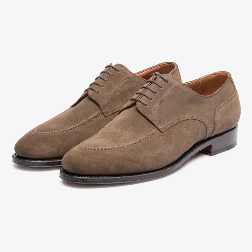 A pair of brown suede dress shoes with a sleek design and lace-up closure.