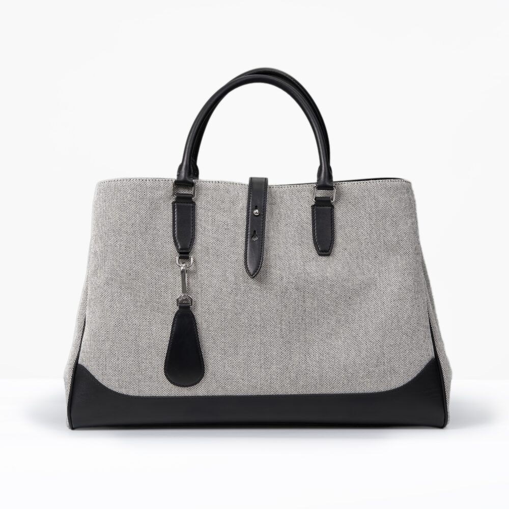A gray and black handbag with two handles and a detachable tag.