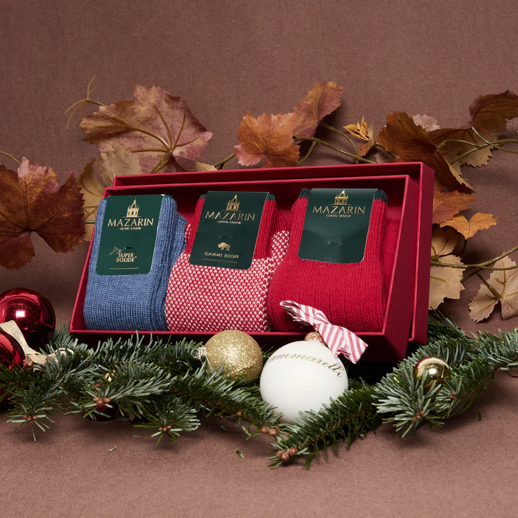 A red gift box contains three pairs of socks in blue, red, and a red and white pattern, labeled "MAZARIN."