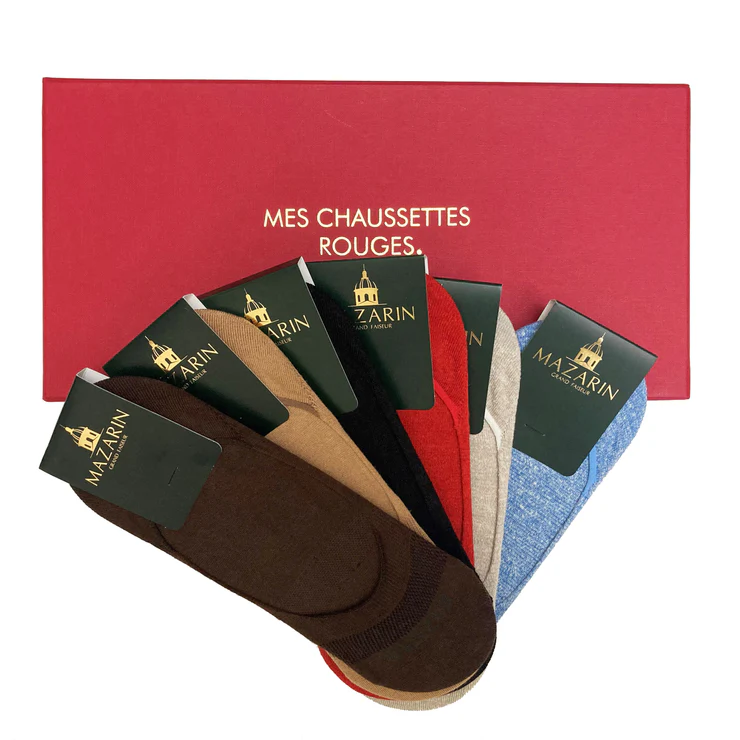 A collection of six pairs of socks in various colors, including brown, beige, red, and blue, displayed in front of a red box with gold text.
