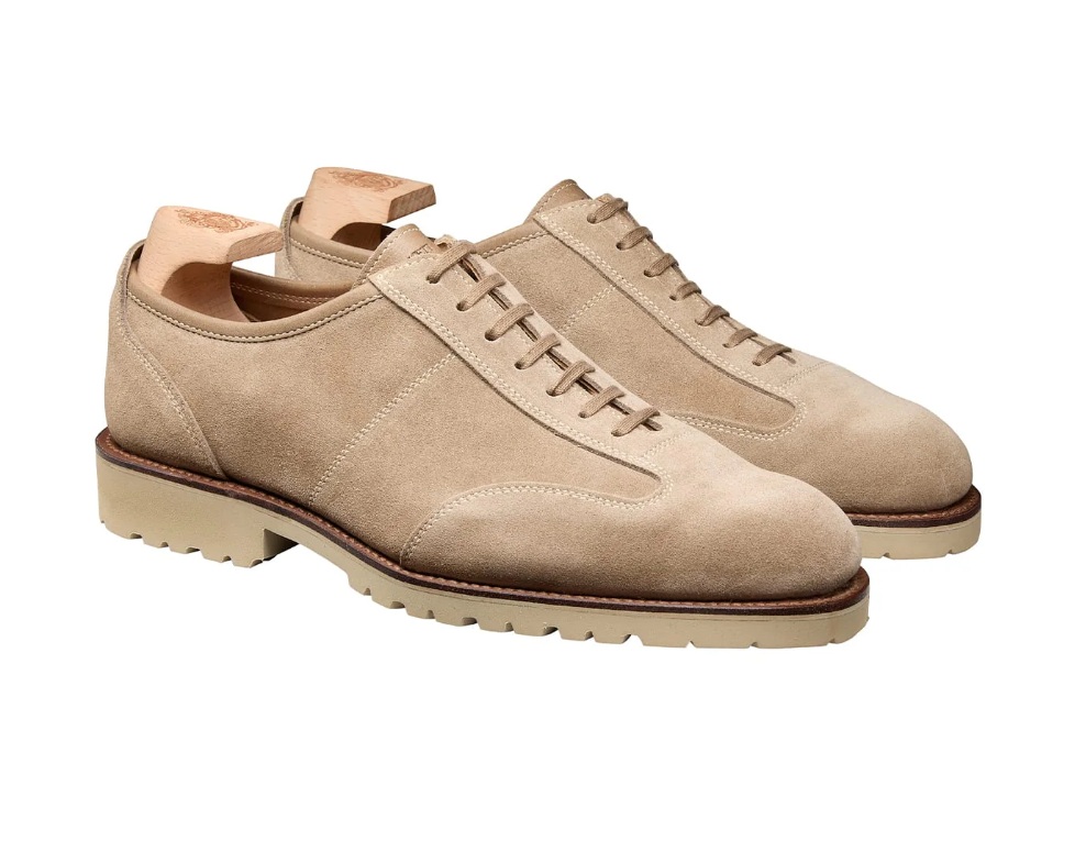 Beige suede shoes with a rubber sole and laces.