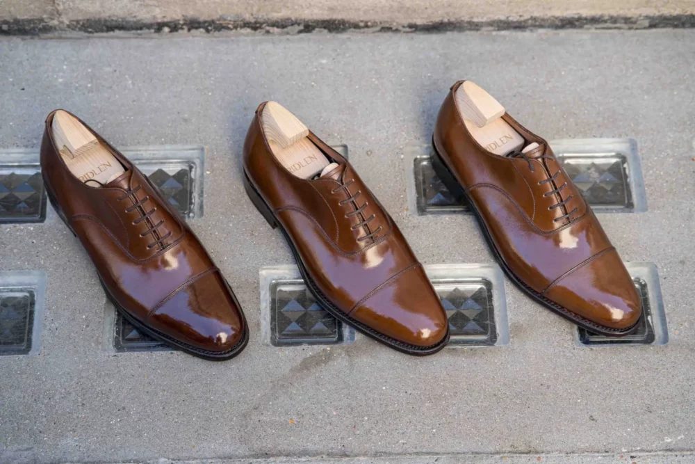 Three pairs of polished brown leather dress shoes with cap toes and lace-up fronts.