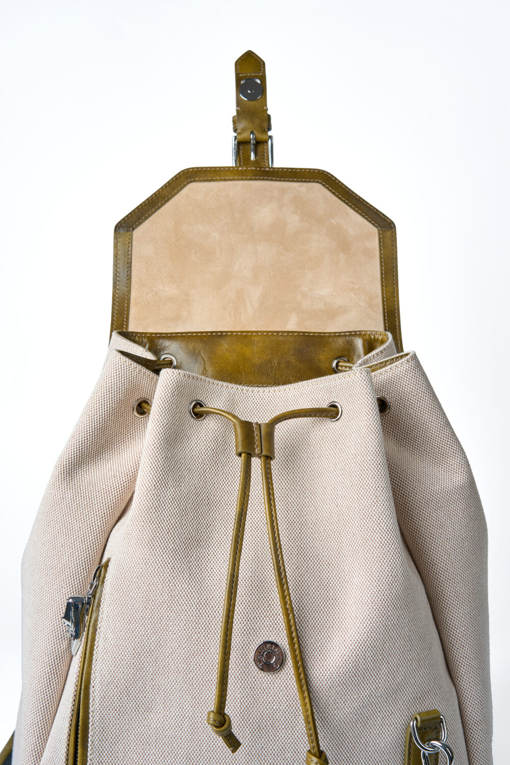 A beige drawstring backpack with olive green leather accents and a smooth, tan suede top.