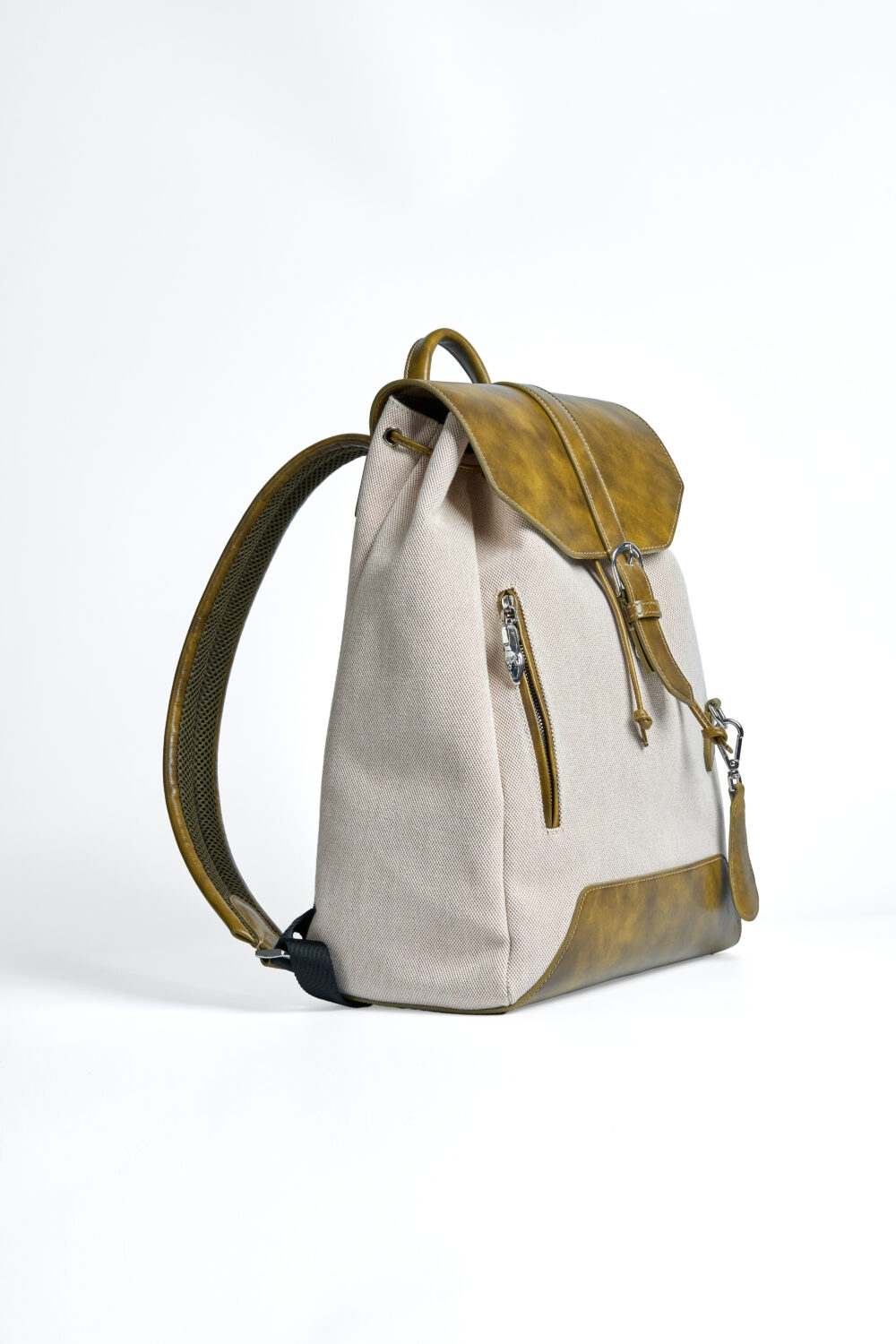 A beige backpack with a yellowish-brown leather flap and accents.