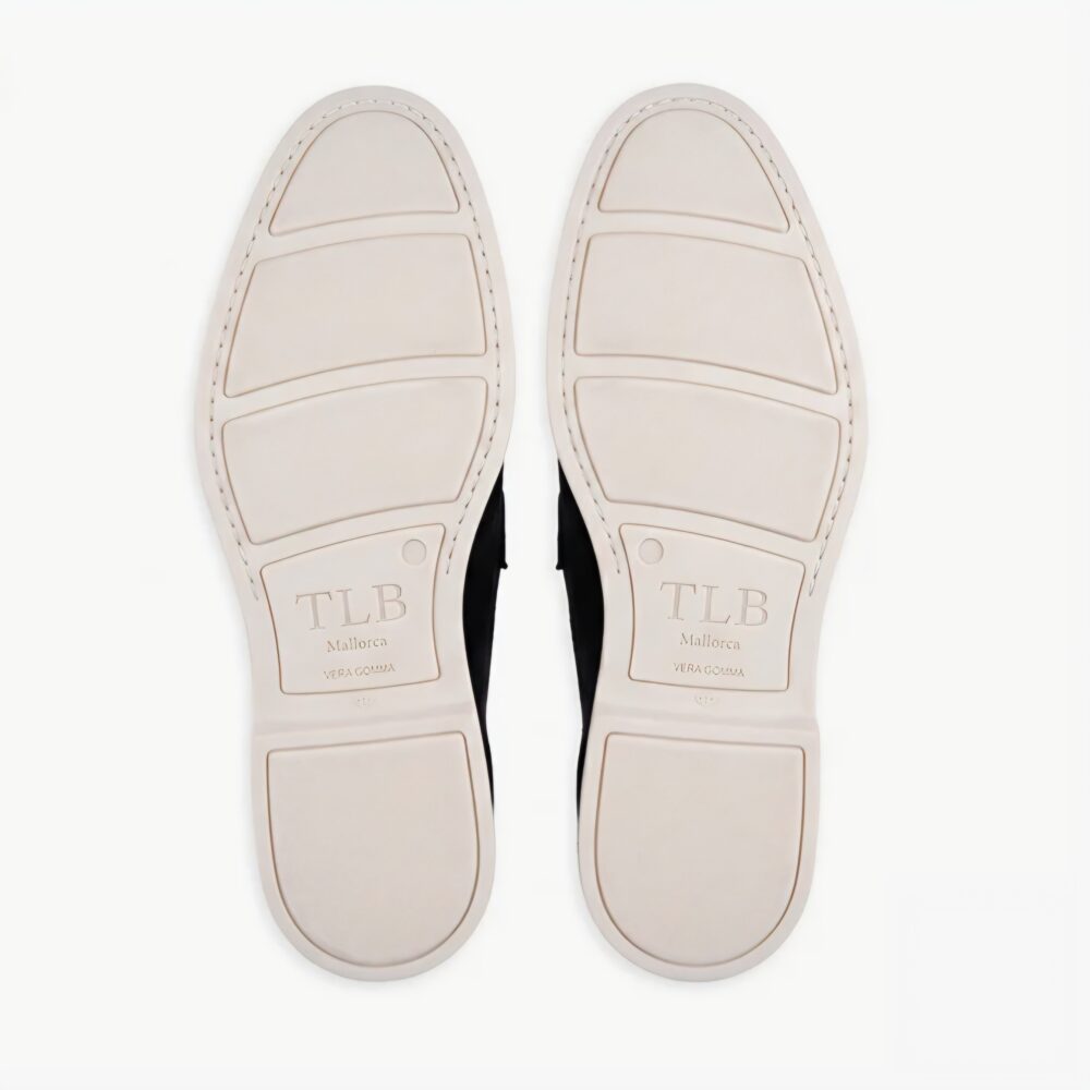 The image shows the white soles of black shoes with "TLB Mallorca" embossed on them.