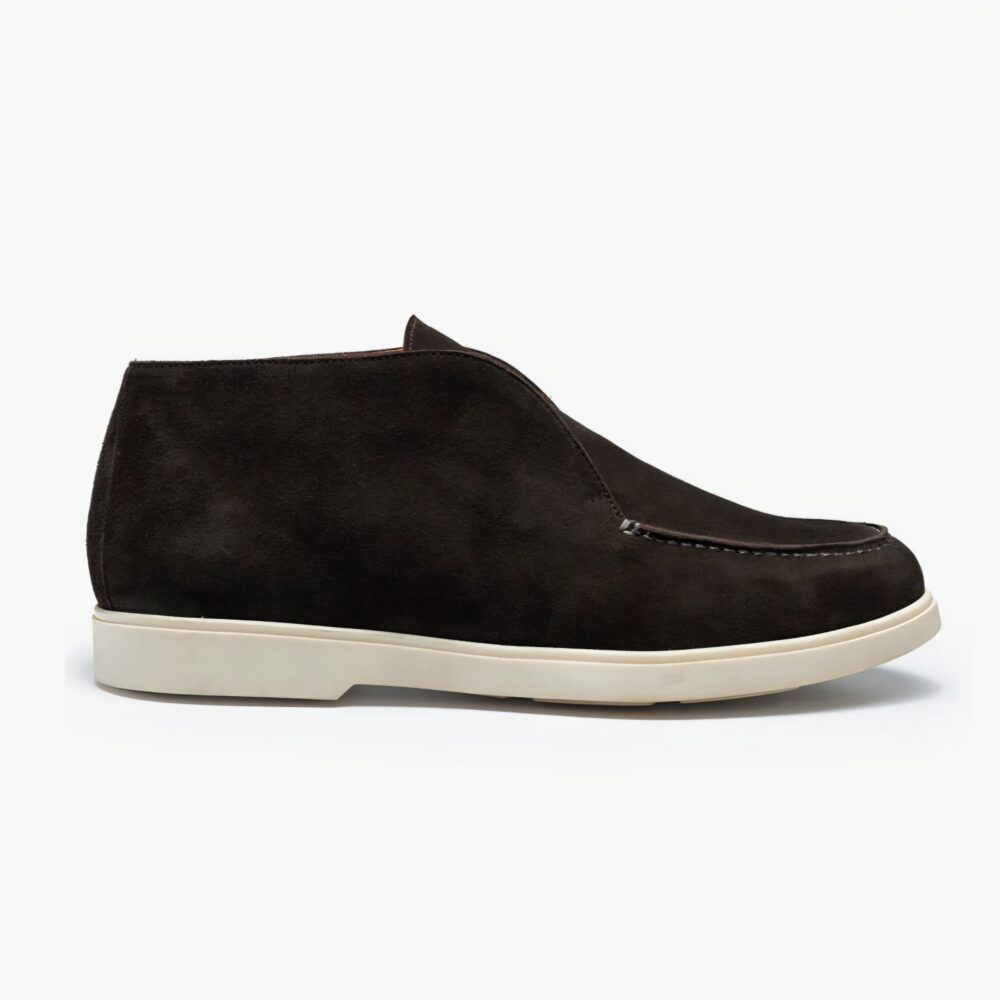 A dark brown suede ankle boot with a white sole.