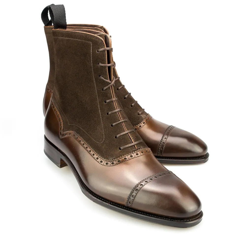 Brown leather and suede ankle boots featuring a lace-up design and brogue detailing.