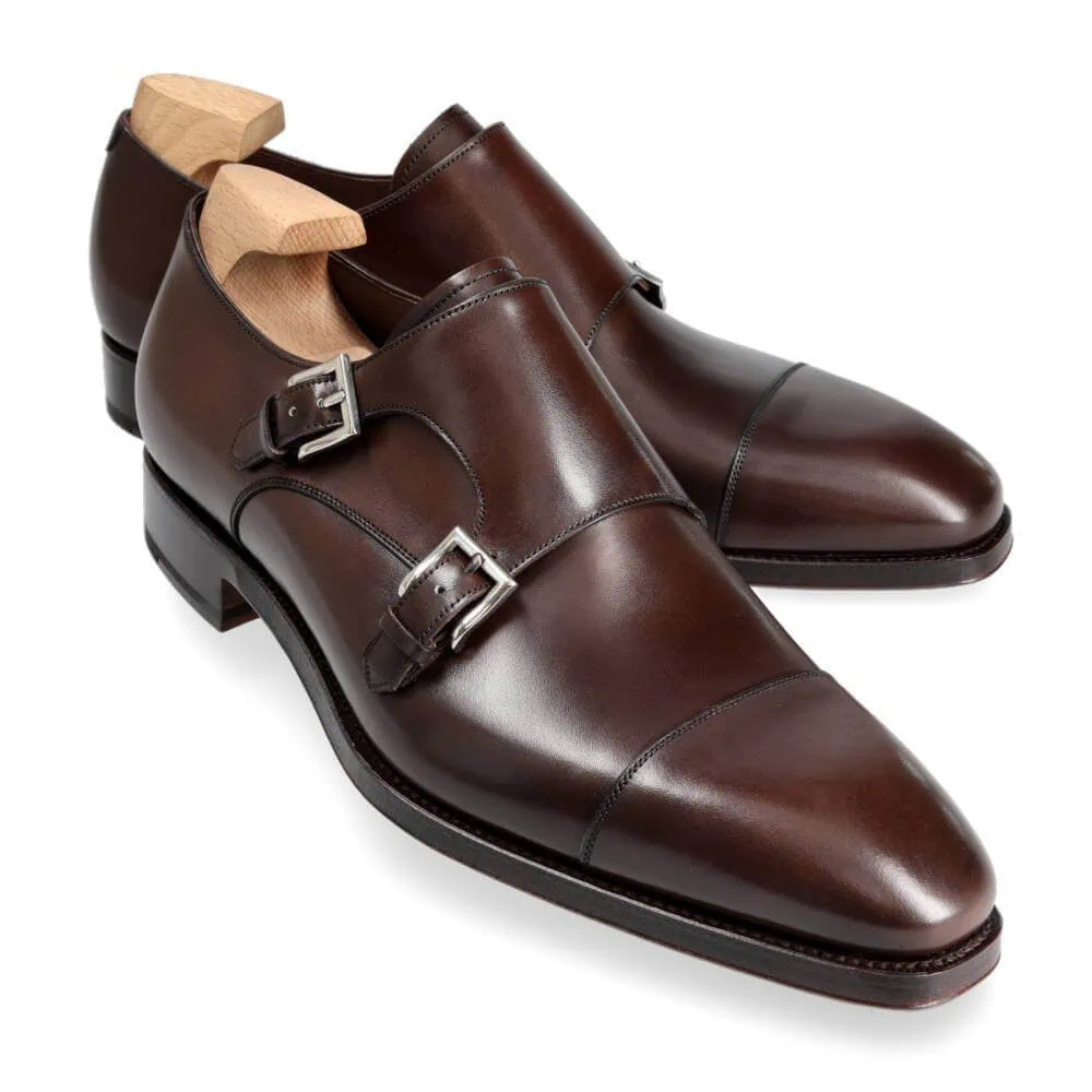 Brown leather dress shoes with two silver buckles.