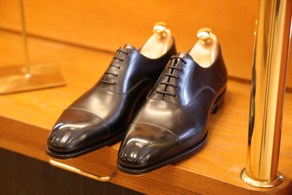 A pair of black leather dress shoes with a polished finish and pointed toes.